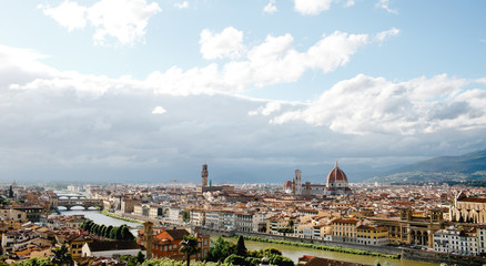 Fototapeta na wymiar Florence looks gorgeous while white clouds fly over it in a sunn