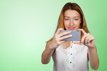 Close up portrait of a young fashionable woman holding a smartphone