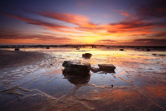 Fototapeta Sunrise reflections across Long Reef Australia
