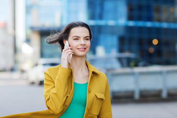 smiling young woman or girl calling on smartphone