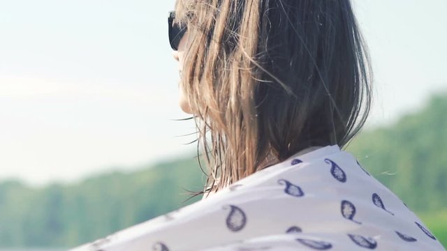 Happy woman turning around with pareo on sky background. Slowly