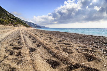 The trace of a tire in the sand on the beach