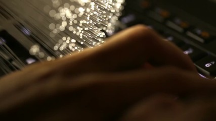 typing on keyboard with Fiber optics background, shot in HD