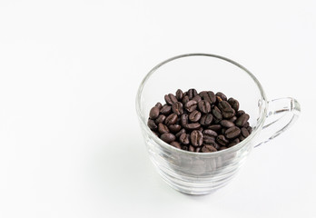 Clear glass cup with the roasted coffee beans.