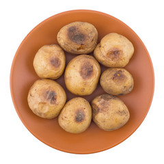 Baked potato in a brown plate isolated on white.