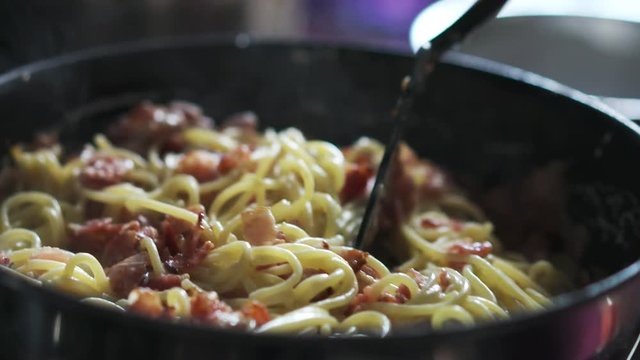 spaghetti carbonara with bacon mixing in 180fps slow motion