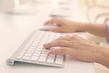 Woman typing on computer keyboard