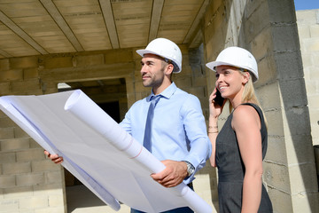 cute young woman architect with handsome foreman in building industry construction site