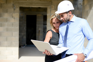 cute young woman architect with handsome foreman in building industry construction site