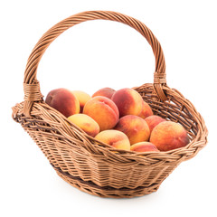 Basket full of fresh peaches isolated on white background.