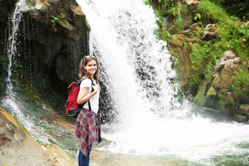 Female tourist standing beside the mountain river