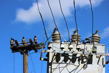Obraz premium electrical wires extending from the transformer station near the railway on a background of blue sky.