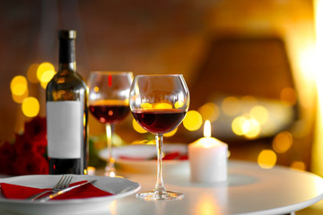 Romantic composition with wine and candle on blurred background