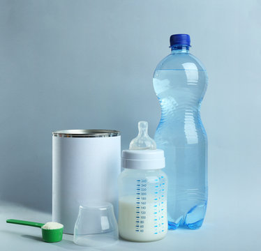 Baby milk formula and bottles on color background