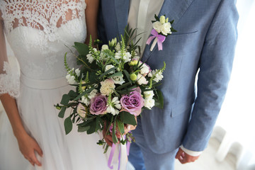 Groom and bride with beautiful bouquet, closeup