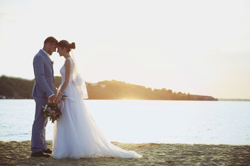 Fototapeta na wymiar Groom and bride on sunset background