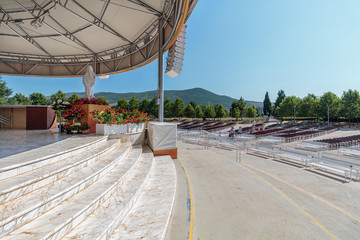 Benches and altar behind the parish church of St. James, the shrine of Our Lady of Medugorje