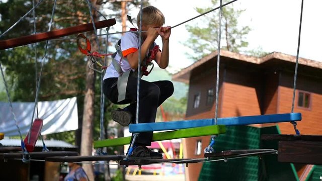 a child climbs on the rope road