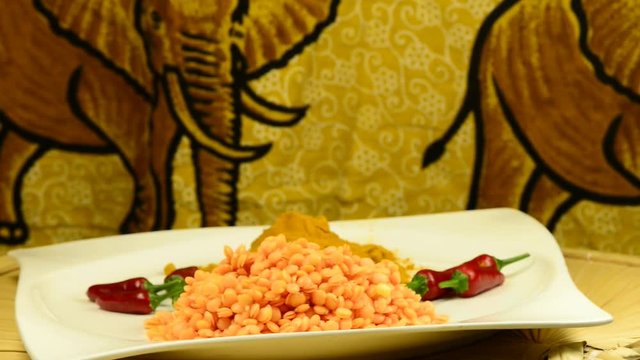 Rote Linsen, Gelbwurz und  Chilis auf einem Drehteller