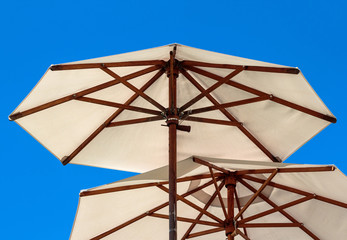 Open wooden construction parasols, blue sky background