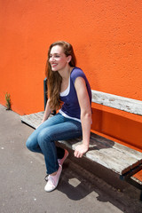 profile of gorgeous young woman smiling sitting on university bench
