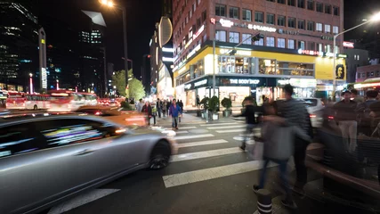 Tuinposter SEOUL, SOUTH KOREA - OCTOBER 22, 2015: Pedestrians crossing the road on zebra in big night illuminated city © danr13