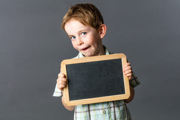 cheeky kid showing an empty writing slate for school learning