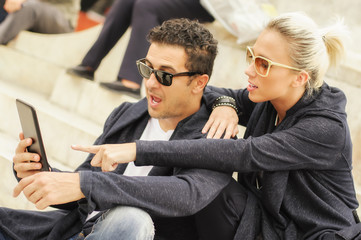 Beautiful couple with tablet in the city