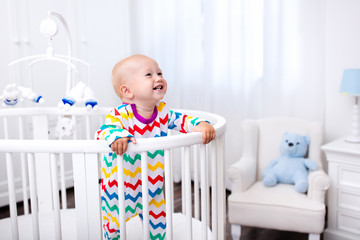 Little boy standing in bed