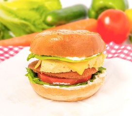 closeup of a sandwich on a cutting board with ingredients on the background