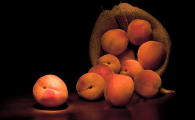 Fresh ripe juicy whole red peaches in on rough black background.