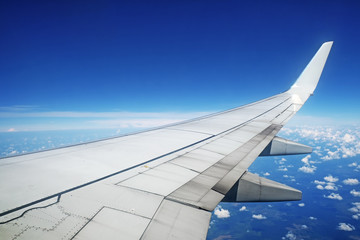 Fototapeta na wymiar Aircraft wing in flight on blue sky background