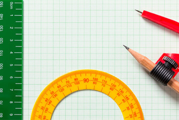 Drawing Compasses and Ruler on green graph paper with copy space