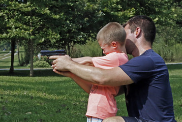 Father teaching his son about gun safety and proper use.