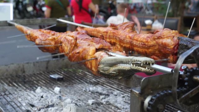 Fried crocodile meat on a barbeque for sale at the street's restaurant