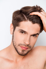 Obraz premium Portrait of handsome bearded man combining his hair