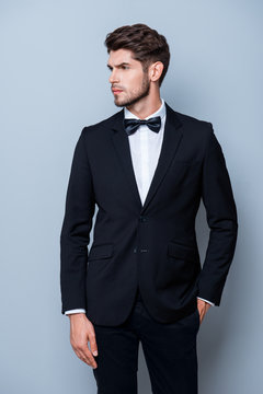 Serious sexy man in black suit holding hand in pocket