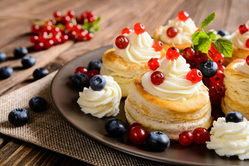 Puff pastry cakes filled with whipped cream and berries