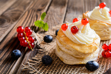 Puff pastry cakes filled with whipped cream and berries