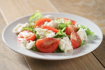 salad with tomatoes, mozzarella, rocket salad and cedar nuts