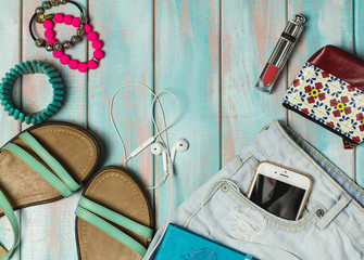 Sandals, headphones and accessories, set out for a walk on a rustic wooden background