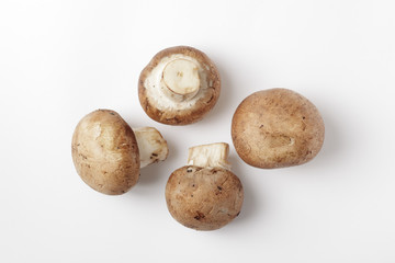 collection of brown, fresh crimini/cremini mushrooms on a white background