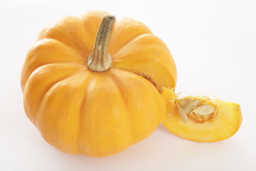 close-up view of pumpkin and a slice on white, isolated background