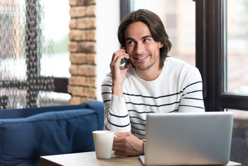 Cheerful man talking on cell phone