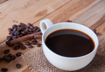 Hot coffee and coffee bean on wooden background