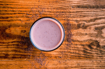 A glass of chocolate on wooden background from above.