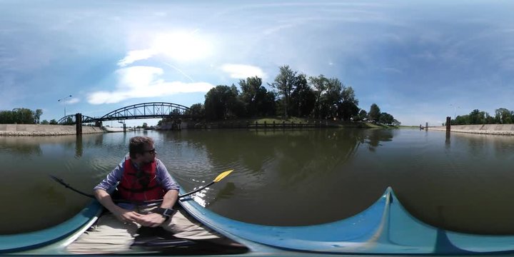 360Vr Video Man Kayaking by River Toward Bridge Sunny Summer Day Man Has Sports at the Nature Green Trees Grass Island in a Pond Horizon Blue Clear Sky