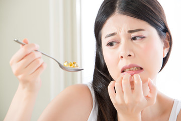 beautiful asian woman scared to eat too much nutritional supplem