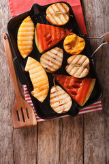 Healthy food: apple, melon, pear, watermelon and peach on a grill pan. vertical top view

