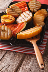 apples, melon, pear, watermelon and peach on a grill pan close-up. vertical
